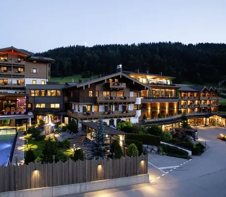 Außenansicht der Riederalm mit beleuchteten Fenstern bei Nacht