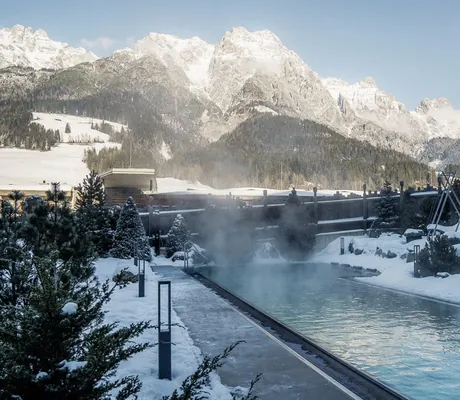 Outdoorpool in der Riederalm im Winter im Schnee mit Blick auf die Berge