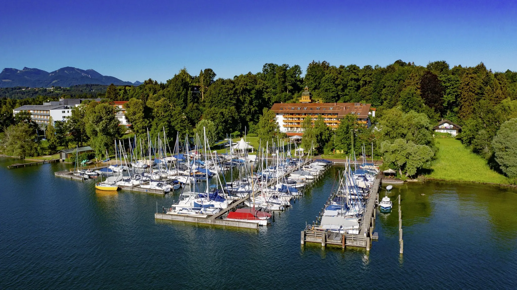 Gesamtansicht Yachthotel Chiemsee inklusive Yachthafen und Garten