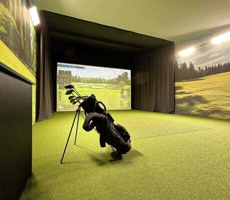 Golfbag mit Schlägern in der Indoorgolfanlage mit Golfbildern im Yachthotel Chiemsee