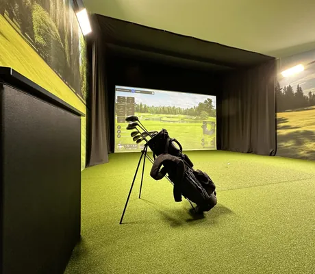 Golfbag mit Schlägern in der Indoorgolfanlage mit Golfbildern im Yachthotel Chiemsee