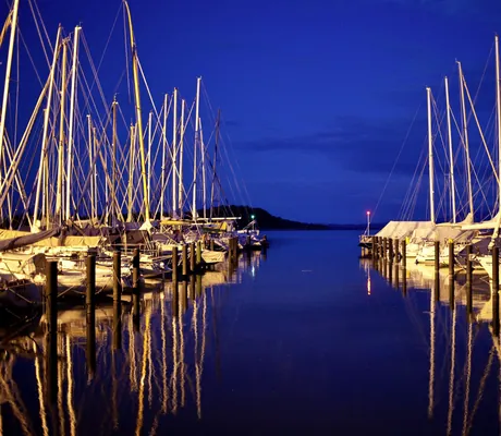 Segelboote am Yachthafen des Yachthotel Chiemsee bei Nacht