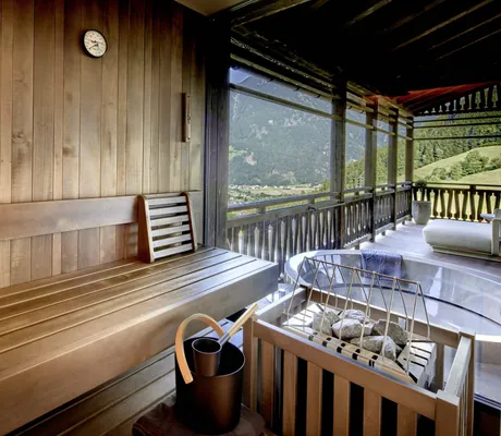 Blick von der Chaletsauna der Amonti Chalets auf den grauen Whirlpool auf der Terrasse