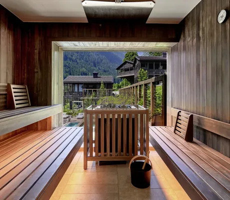 Blick von der Sauna des Spa House in den Amonti Chalets auf die Holzhäuser