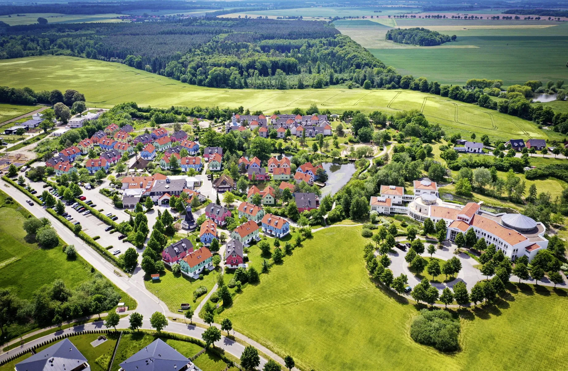 Gesamtansicht BEECH Resort Fleesensee von oben mit Blick auf Wiesen und Wälder