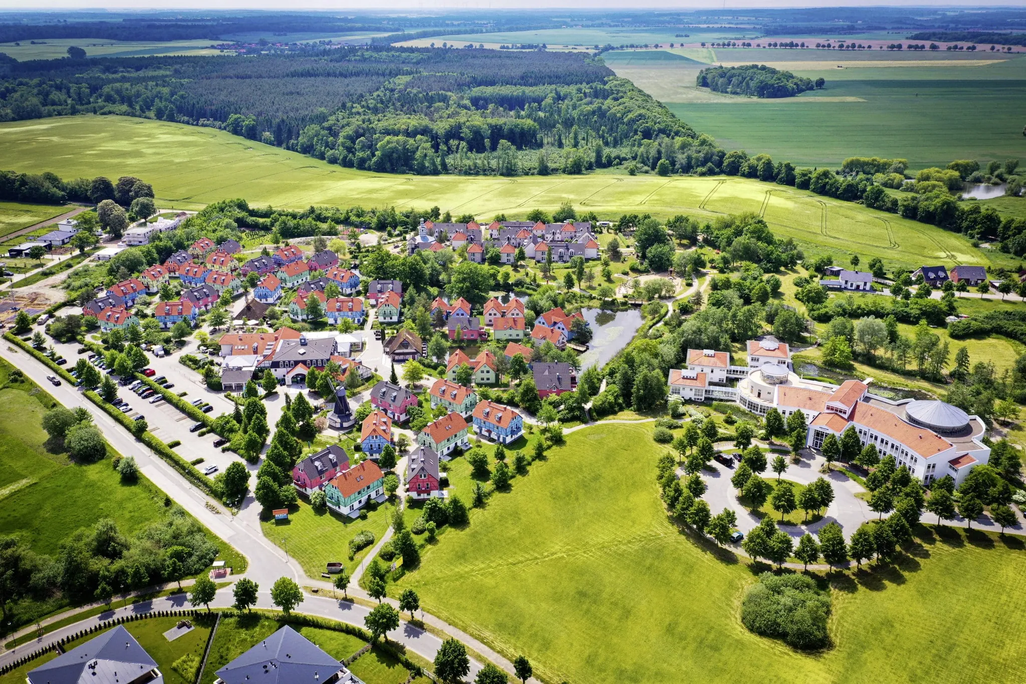 Gesamtansicht BEECH Resort Fleesensee von oben mit Blick auf Wiesen und Wälder