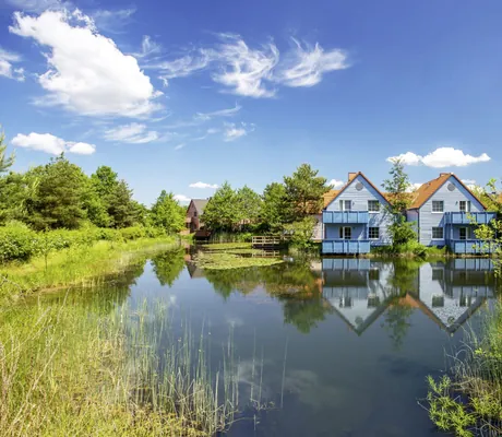 Fassaden der Häuschen im BEECH Resort Fleesensee vom Naturteich aus