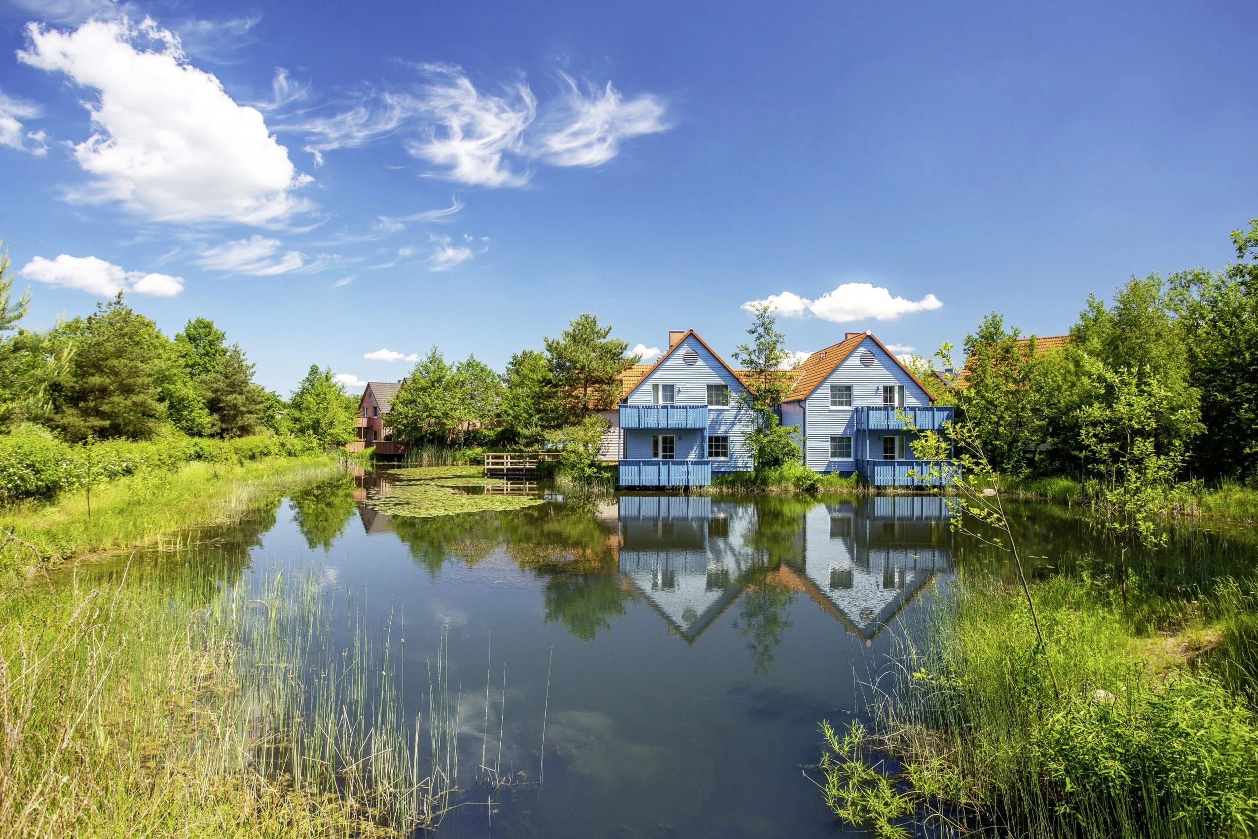 Fassaden der Häuschen im BEECH Resort Fleesensee vom Naturteich aus