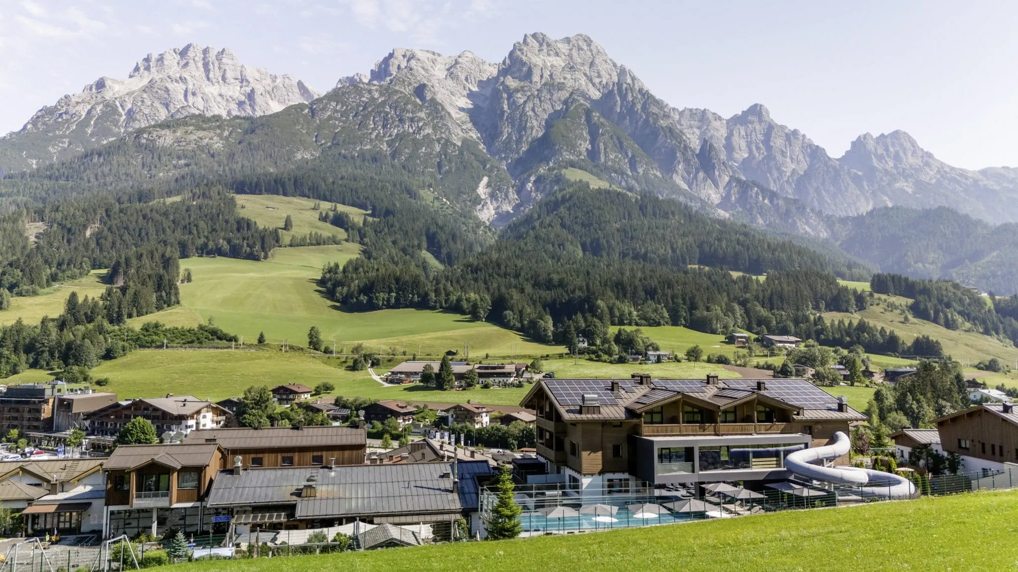 Außenansicht des Familienbereichs der Riederalm mit Familypool und Wasserrutsche