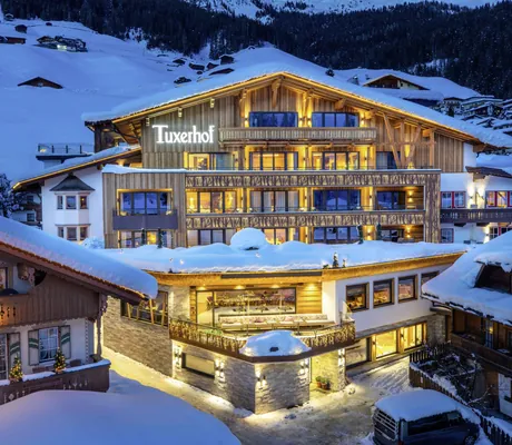 beleuchtete Fassade des Tuxerhof im Winter mit Schriftzug