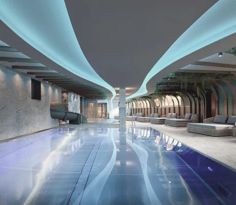 Indoorpool im Tuxerhof mit wellenförmiger Deckenbeleuchtung und Wasserrutsche