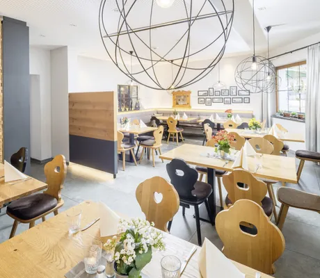 Restaurant im Hundesporthotel Wolf mit alpinen schwarzen und holzfarbenen Stühlen