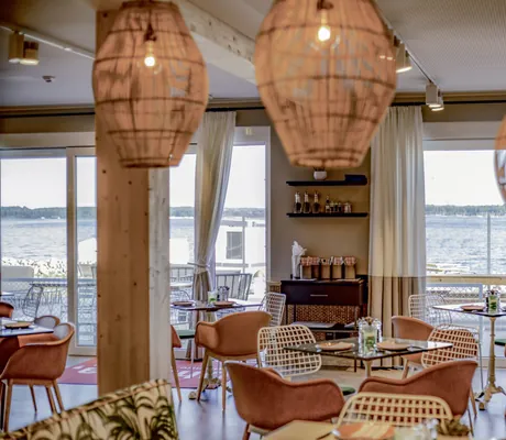 Restaurant im Maremüritz Yachthafen Resort mit Korblampen und rostroten Sesseln mit Blick auf den See