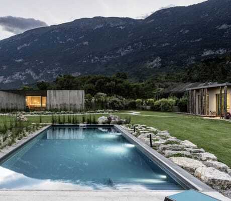 Beleuchteter Outdoorpool im Garten des Agritur La Dolce Mela, umgeben von den Bergen des Trentino