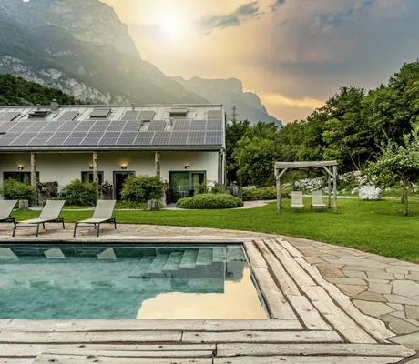 Outdoorpool mit aufgehender Sonne im Hintergrund im Garten des Agritur La Dolce Mela