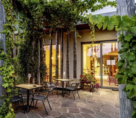 In der Abenddämmerung beleuchtete Veranda mit Sitzgelegenheiten im Agritur La Dolce Mela