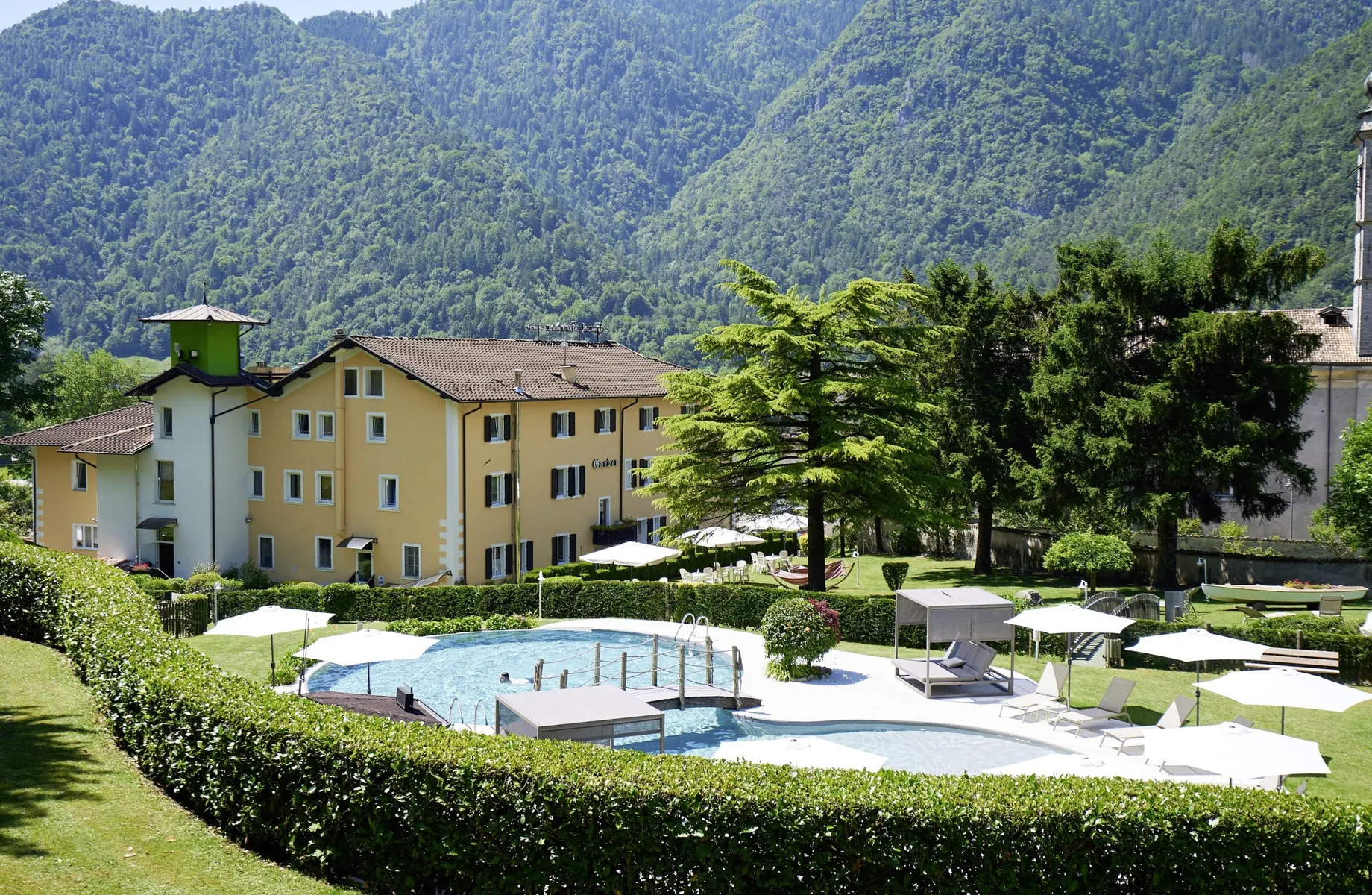 Blick auf das Good Life Hotel Garden am Ledrosee mit Outdoorpool im Garten