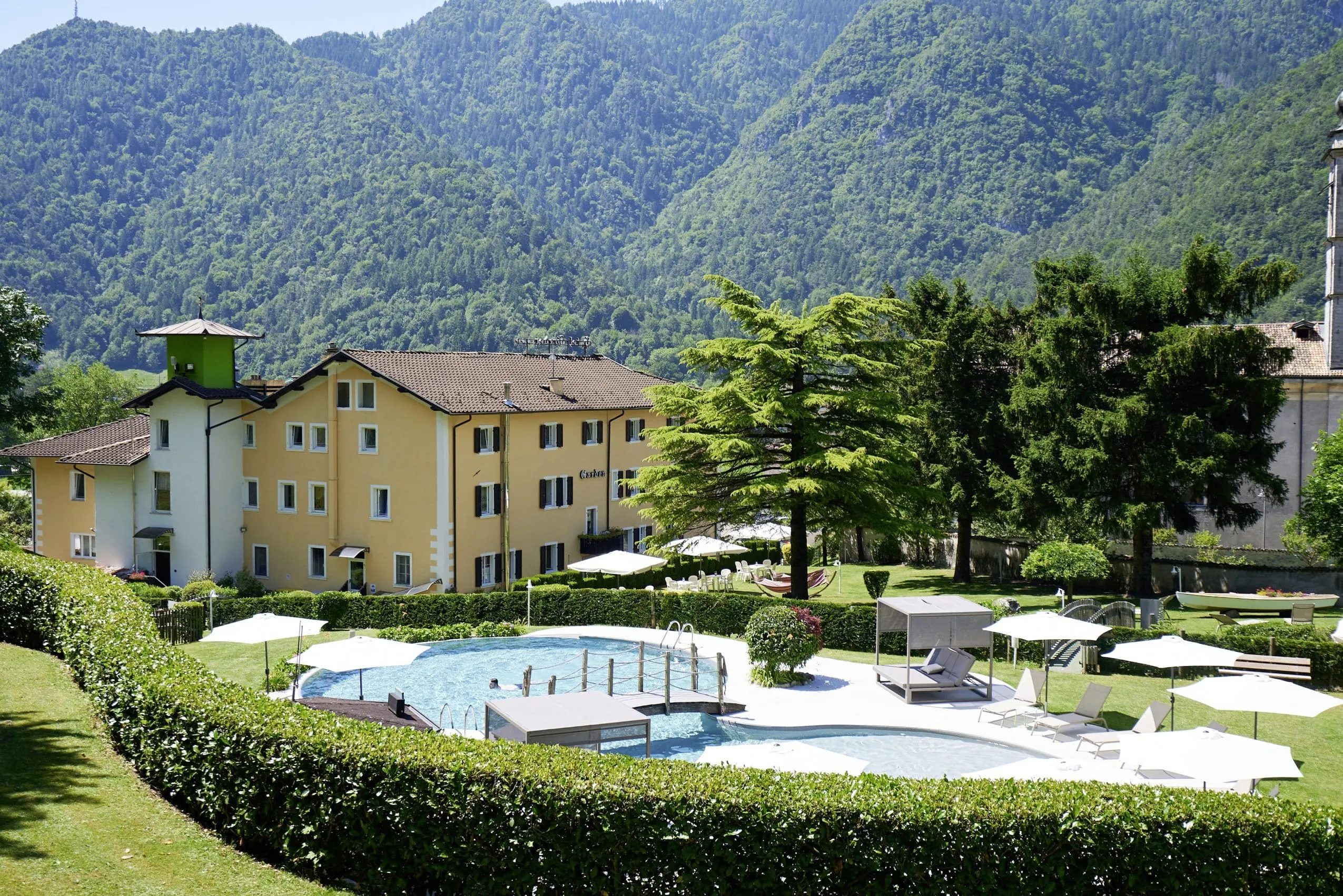 Blick auf das Good Life Hotel Garden am Ledrosee mit Outdoorpool im Garten