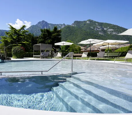 Outdoorpool im Good Life Hotel Garden im Sommer mit Liegen und Blick auf die umliegenden Berge
