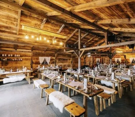 eingedeckte Tische in der Alm-Eventhütte mit Fellen im Freizeit In
