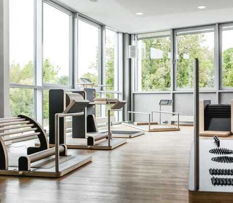 Fitnessraum im Hotel am Vitalpark mit Holzgeräten und großen Fenstern