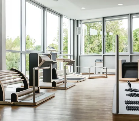 Fitnessraum im Hotel am Vitalpark mit Holzgeräten und großen Fenstern