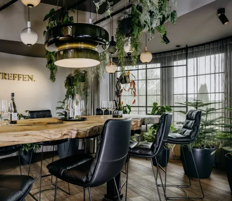 Besprechungstisch im Landhotel Rössle mit schwarzen Ledersesseln und Hängepflanzen an der Decke