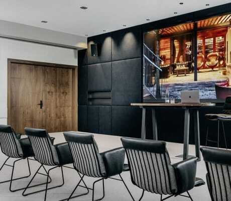 schwarze Ledersessel im Tagungsraum des Landhotel Rössle vor schwarzer Wand mit großem Screen