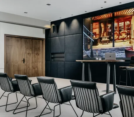 schwarze Ledersessel im Tagungsraum des Landhotel Rössle vor schwarzer Wand mit großem Screen