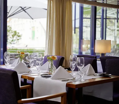 Restaurant mit eingedeckten Tischen und blauen Sesseln im Parkhotel Pforzheim
