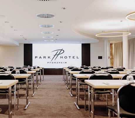Tagungsraum im Parkhotel Pforzheim mit Reihenbestuhlung und großem Logo auf dem Screen