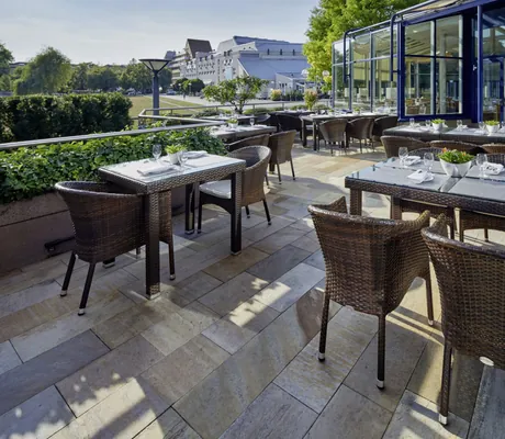 Terrasse im Parkhotel Pforzheim mit Korbstühlen an den eingedeckten Tischen und Blick in die Stadt