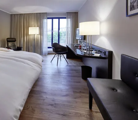 Doppelzimmer im Parkhotel Pforzheim mit schwarzer Lederbank und Vogeltapete am Bettkopf