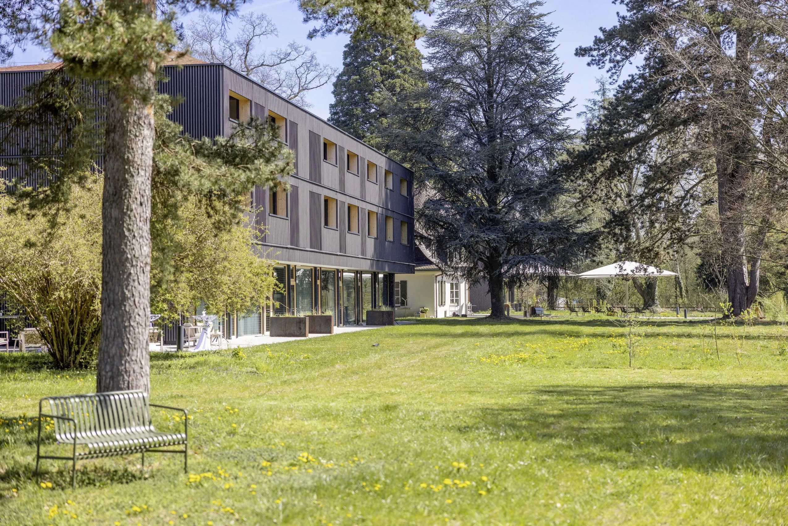 Fassade des Seegut Zeppelin vom Park aus gesehen mit altem Baumbestand