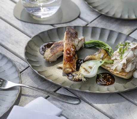 Hähnchengericht auf geriffeltem Teller mit Lauchzwiebeln im Seegut Zeppelin