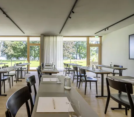 Tagungsraum im Seegut Zeppelin mit schwarzen Stühlen und Blick auf den Bodensee
