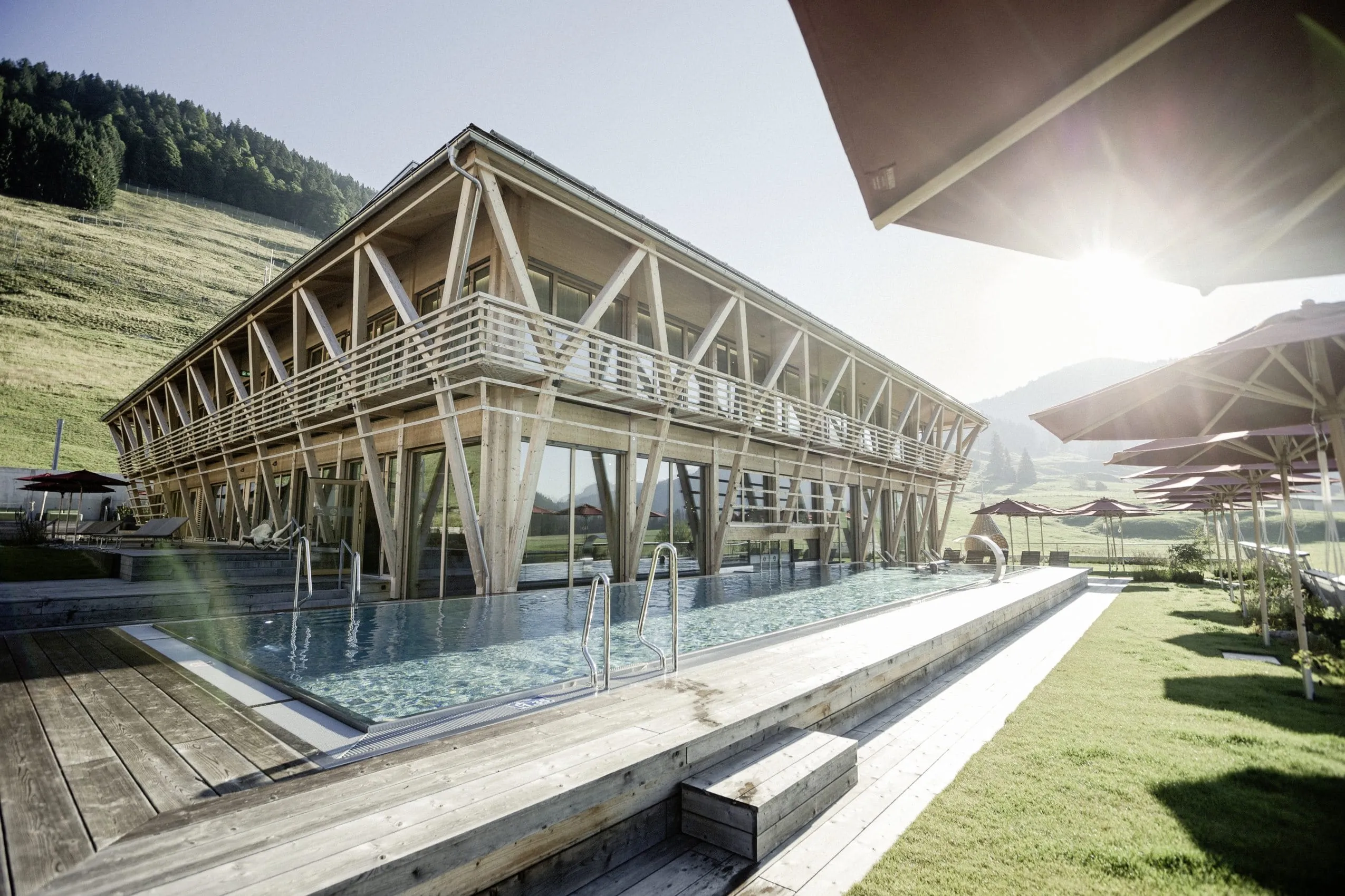 Mountain Spring Spa in nat&uuml;rlicher Holzbauweise mit Outdoorpool im Vordergrund