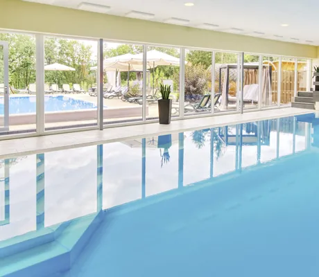Indoorpool im Aktiv & Vitalhotel Thüringen mit Blick durchs Fenster auf den Outdoorpool