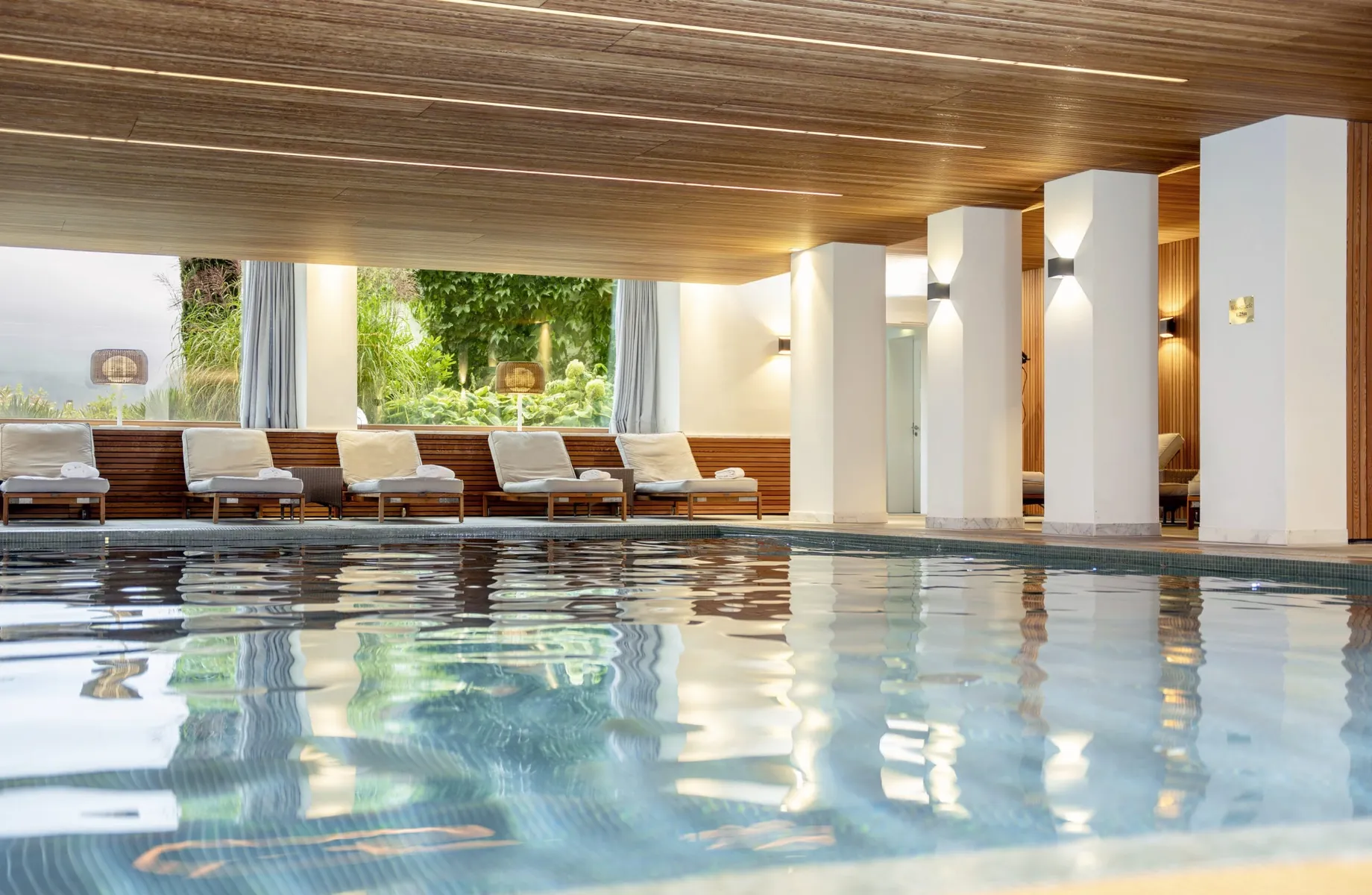 Indoorpool im Hotel Allgäu Sonne mit Holzdecke und Blick in den Garten