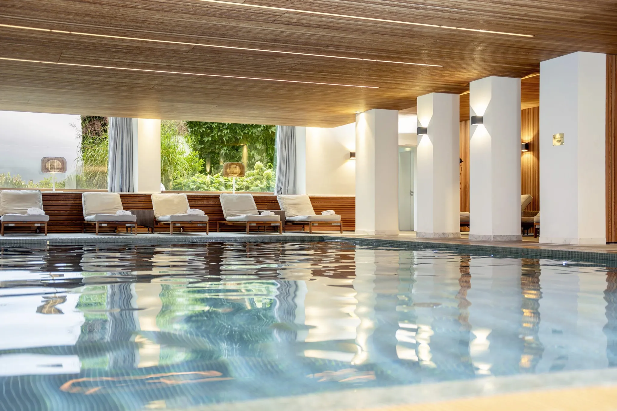 Indoorpool im Hotel Allgäu Sonne mit Holzdecke und Blick in den Garten
