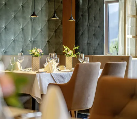 festlich gedeckter Tisch im Restaurant des Alpbacherhof mit gepolsterter Wand