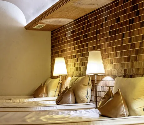 Wasserbetten mit braun-beigen Kissen und Stehlampen in Ruheraum des Alpbacherhof