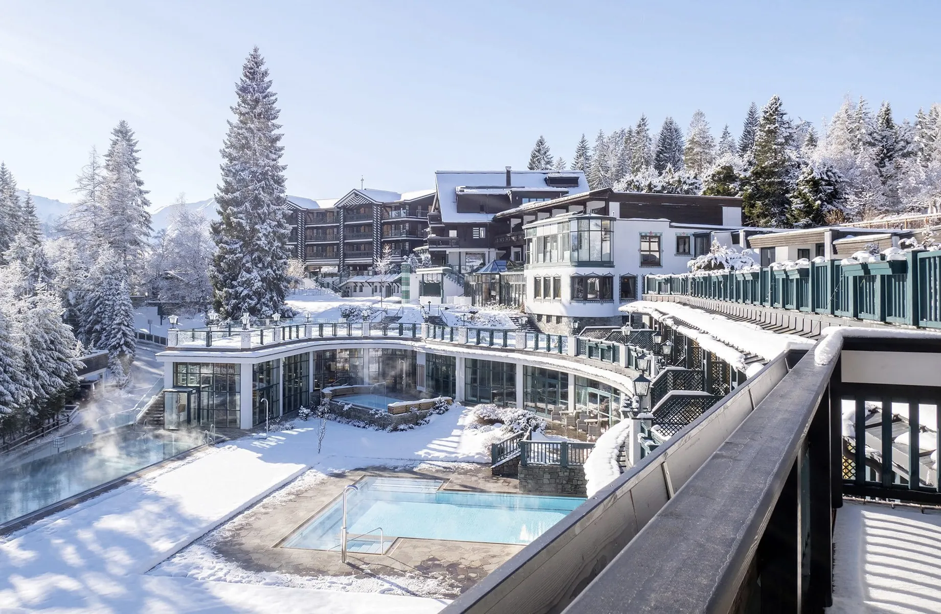 Außenansicht des Alpin Resort Sacher Seefeld im Schnee mit Blick auf den Outdoorpool