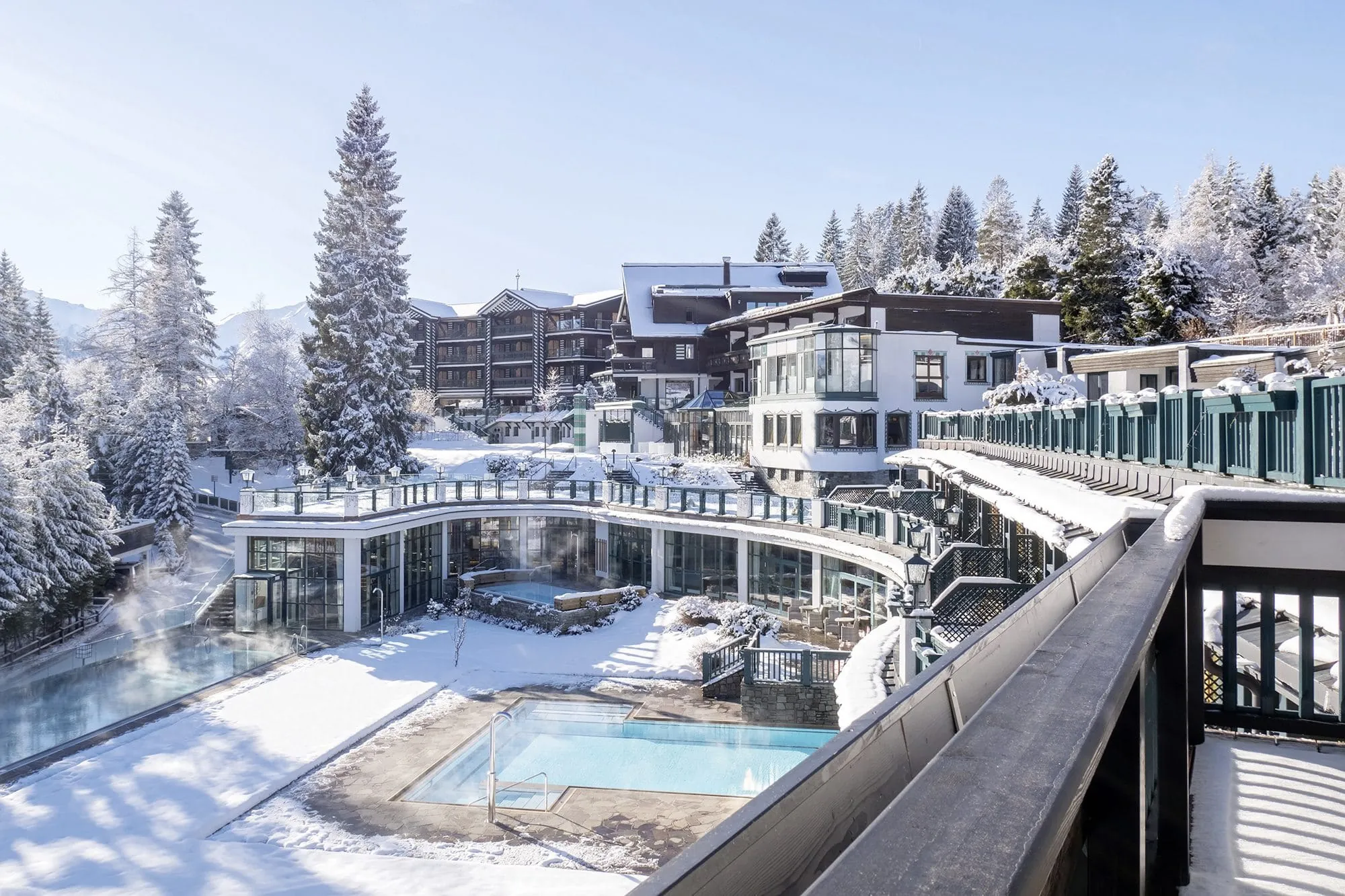 Außenansicht des Alpin Resort Sacher Seefeld im Schnee mit Blick auf den Outdoorpool