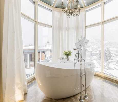 freistehende weiße Badewanne in einem Erker des Alpin Resort Sacher Seefeld