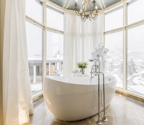 freistehende weiße Badewanne in einem Erker des Alpin Resort Sacher Seefeld