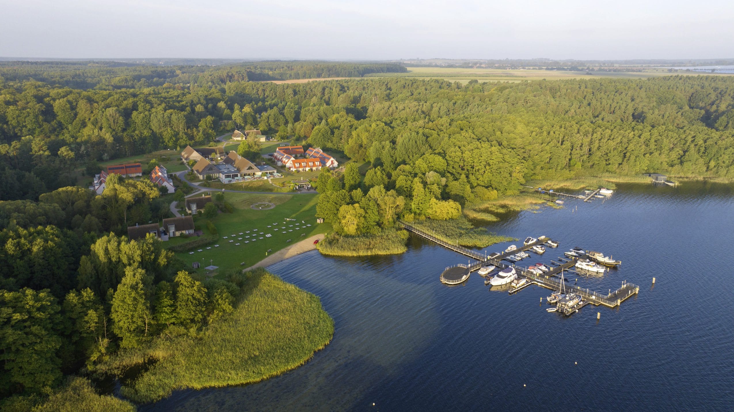Gesamtansicht des BEECH Resort Plauer See von oben mit Blick auf den Hafen