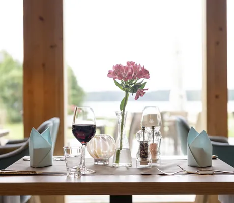 eingedeckter Tisch im Restaurant des BEECH Resort Plauer See mit Blick auf den See