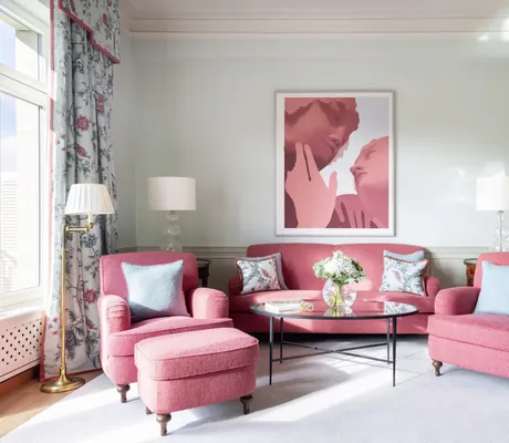 rote Polsterecke im Zimmer des Brenners Park-Hotel & Spa mit modernem Bild mit roten Gesichtern