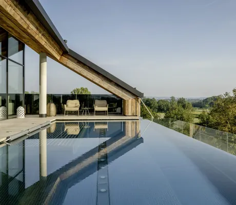 Rooftoppool im Das Mühlbach mit zwei Sesseln unter der Dachschräge und Blick ins Grüne